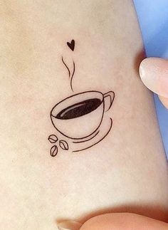 a woman's stomach with a coffee cup tattoo on it