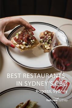 a person is eating food on a plate with a glass of wine in front of them