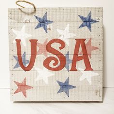 a wooden sign with the word usa written in red, white and blue stars on it