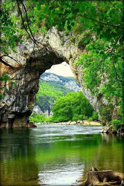 an arch in the side of a river