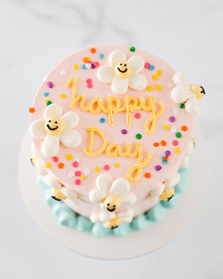 a birthday cake with frosting and sprinkles that says happy day