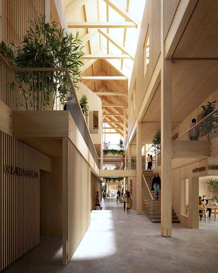 the inside of a building with people walking and sitting on benches in front of it