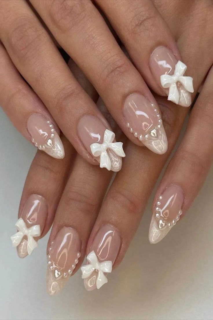 a woman's hands with french manies and bows on their nails, one is white