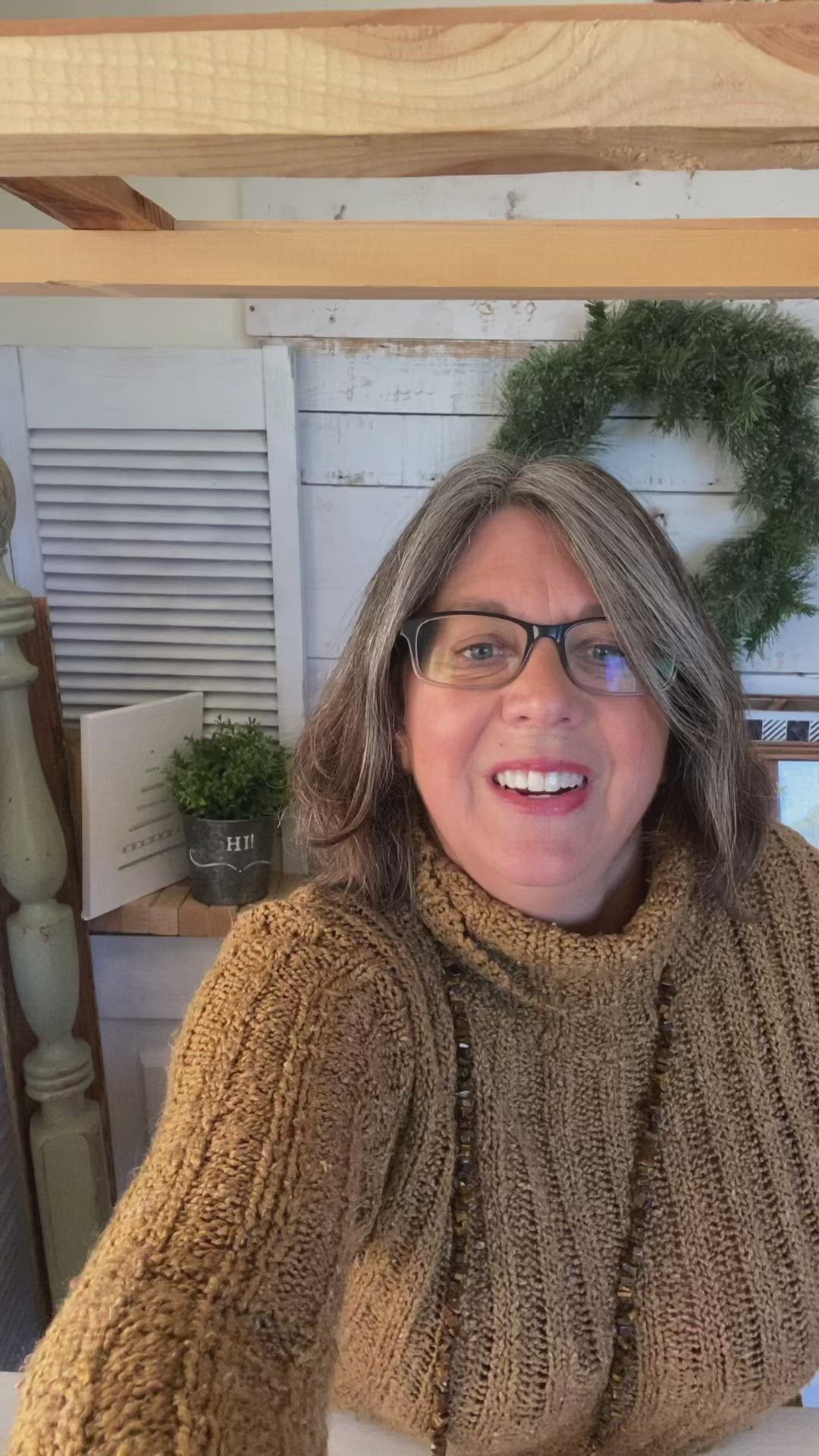 This may contain: a woman holding up a wooden christmas ornament