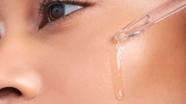 Woman applying vitamin c serum