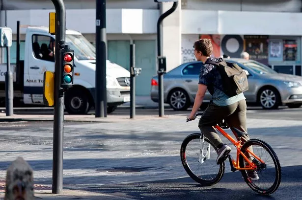 Stock image of man on bike at a traffic light near Castle Street, Cardiff