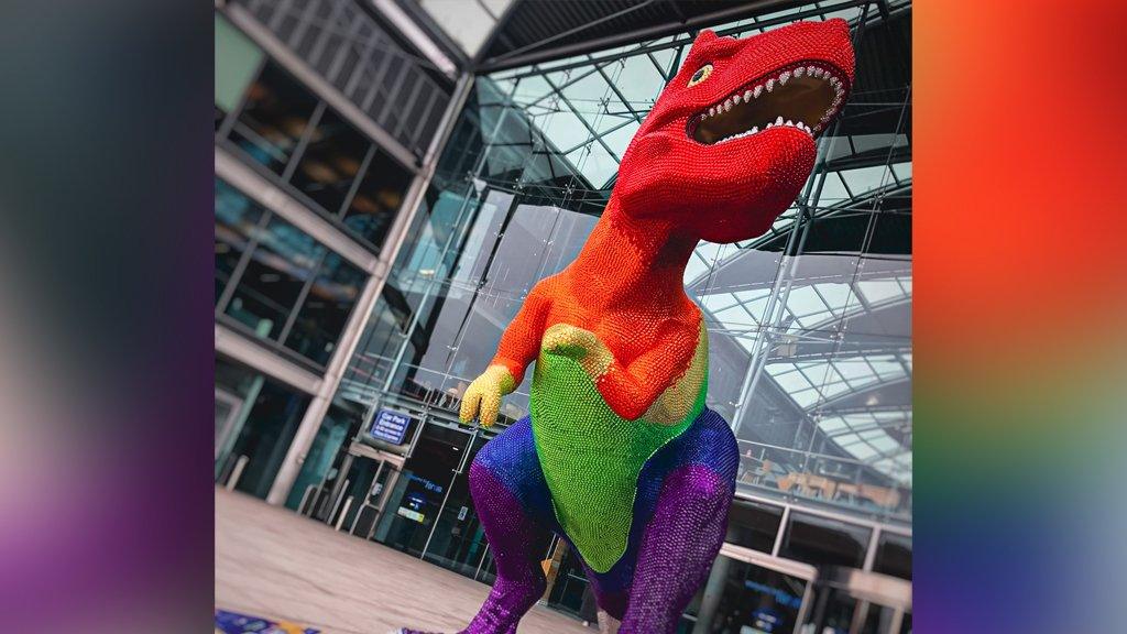 Dinosaur sculpture in Pride colours