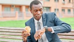 Un homme mange un sandwich en regardant sa montre