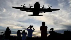 航空爱好者在台湾台北松山机场拍摄一架接近的台湾C-130大力士军用飞机（2023年8月25日）。