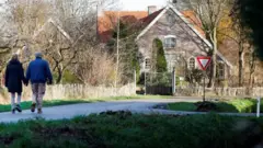 People walk through the village of Ommeren