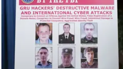 Плакат ФБР с фотографиями объявленных в розыск хакеров, которые, по данным ФБР, работают в ГРУ