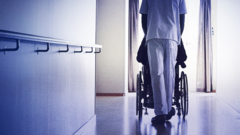 Care worker seen from behind, with wheelchair