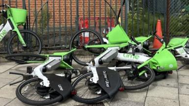 Four out of a group of five dockless e-bikes operated by Lime are laying on their sides with poor parking like this are among the reasons Brent Council has threatened to ban them from the borough