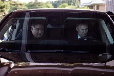 Mr Putin behind the wheel of a car with Mr Kim next to him in the passenger seat