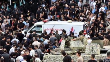 Lebanese army soldiers stand guard as an ambulance arrives after a reported device explosion occurred during the funeral of people killed when hundreds of paging devices exploded in a deadly wave across Lebanon the previous day, in Beirut's southern suburbs on September 18, 2024. 