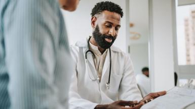 Doctor talking to patient holding clipboard