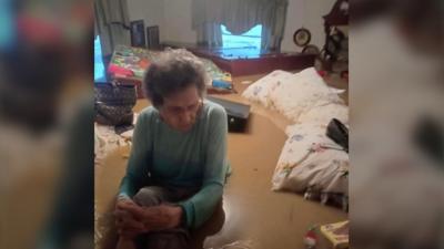 An elderly woman in flood water