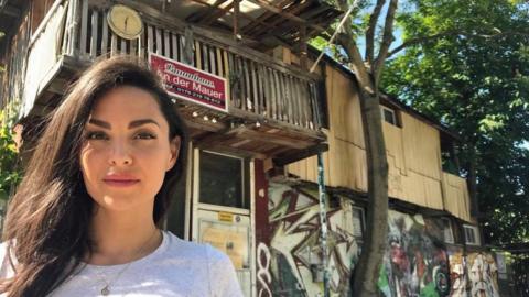 Funda Kalin in front of the tree house her grandfather built