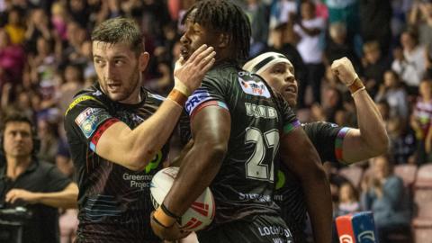 Jake Wardle, Junior Nsemba and Liam Marshall celebrate a try for Wigan