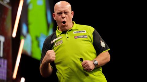 Michael van Gerwen holds up his fist in celebration