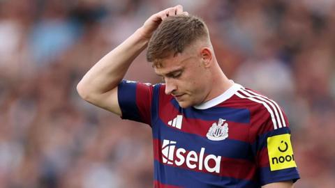 Harvey Barnes scratches his head during Newcastle's Premier League game at Fulham