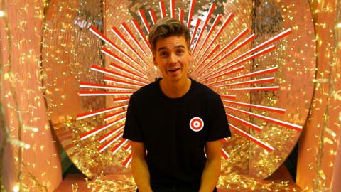 Celebrity vlogger Joe Sugg with black t-shirt on looking to camera.