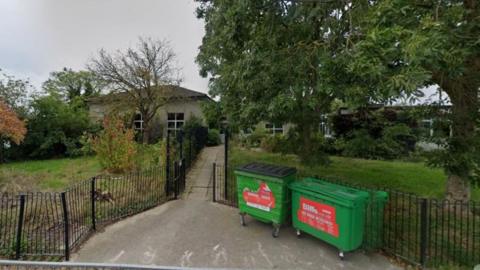 Former school site at Etsome Terrace. Low buildings can be seen behind a green area.