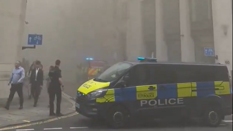 Smoky street filled with people and police car