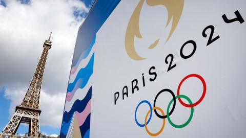 The Paris 2024 logo, representing the Olympic Games is displayed near the Eiffel Tower