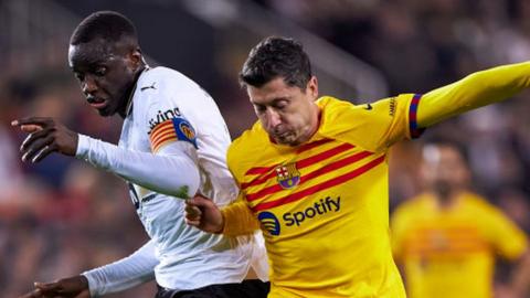 Robert Lewandowski of Barcelona competes for the ball with Mouctar Diakhaby of Valencia
