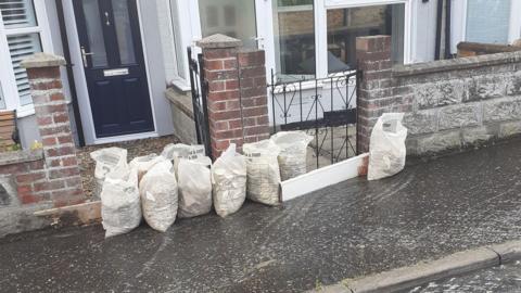 Sand bags outside partially flooded home