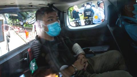 Tong Ying-kit handcuffed inside a police car