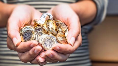 Hands holding pound coins