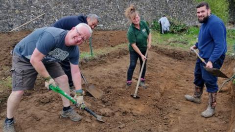 Members from Communigrow dig a hole at the site in East Malling