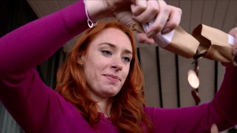 Hannah Fry holds cardboard tubes in front of her