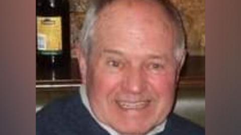 Kenneth Armitage, pictured with grey hair and smiling, wearing a blue jumper.