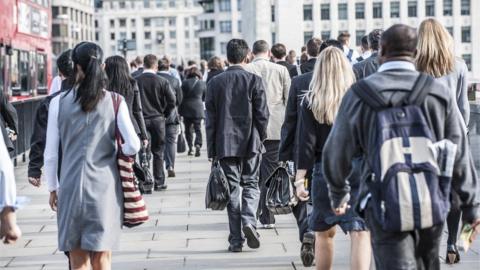 People walking on a pavement, commuting to work