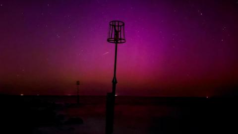 Pole with basket in the sea with aurora skies 