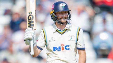 Adam Lyth raises his bat after reaching his second half-century of the match