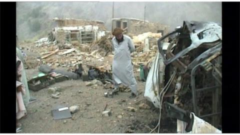 People stand in the aftermath of an airstrike in Afghanistan