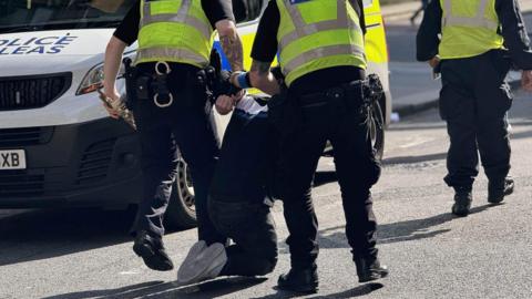 A man being taken away by officers