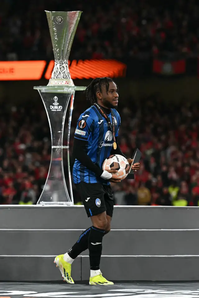 Lookman walks across the stage with his match ball and winners medal