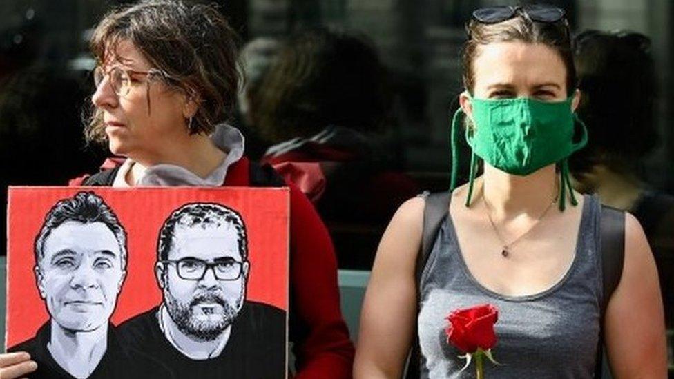 Demonstrators hold placards and roses as they protest following the disappearance, in the Amazon, of journalist Dom Phillips and campaigner Bruno Araujo Pereira, outside the Brazilian Embassy in London, Britain, June 9, 2022.