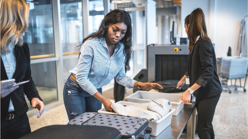 Woman waiting at airport to have her bags searched