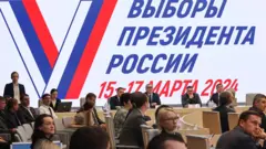 Люди на фоне плаката Выборы президента России