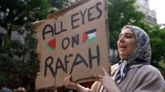 Женщина держит плакат с надписью "All eyes on Rafah"