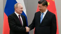 Vladimir Poutine and Xi Jinpingse serrent la main en novembre 2019