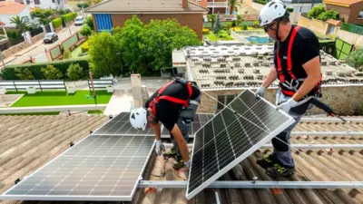 Trabalhadores instalam painéis solares em um telhado