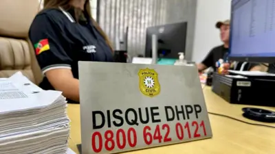 Mulher atrás de placa em escritório que diz: Disque DHPP