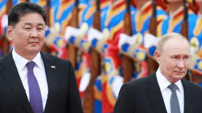 Mongolia's President Ukhnaagiin Khurelsukh and Russia's President Putin walk in front of Mongolian soldiers